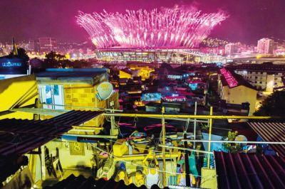 Prebivalci favel opazujejo spektakularno otvoritev olimpijskih iger.
