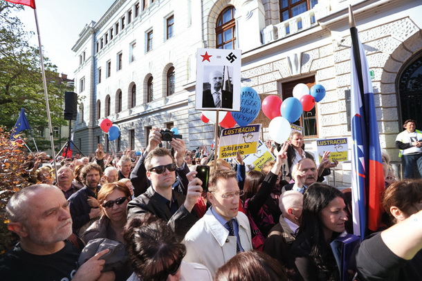 Klemen Jaklič (na sredini, v svetlem dežnem plašču) na protestih v podporo Janezu Janši pred sodiščem v Ljubljani 