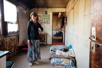 Tatjana Brajdič s spečo vnukinjo v svojem domovanju, kovinskem zabojniku, ki v osnovi ni namenjen za bivanje ljudi
