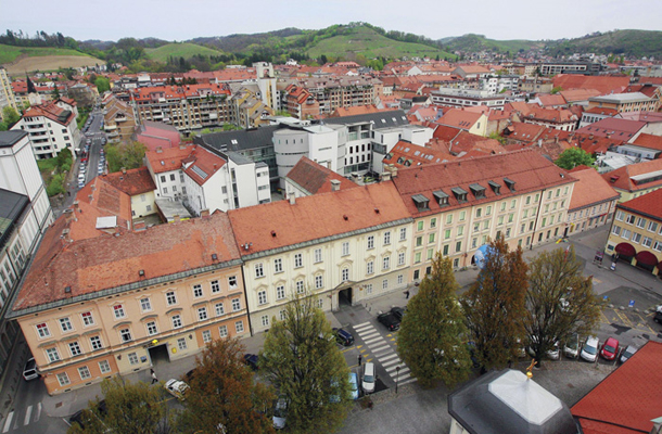 Slomškov trg v Mariboru, pogled na stavbo, kjer je sedež nadškofije in zadaj Andreanum s teološko fakulteto. Graška škofija namerava kupiti sedež, brez teološke fakultete. 