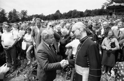 Stisk roke predsednika Milana Kučana in ljubljanskega nadškofa dr. Alojzija Šuštarja na spravni slovesnosti, Kočevski rog,  8. julij 1990