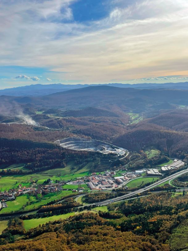 Izkoriščanje rudnin, ki so omejeno naravno in družbeno bogastvo, za sabo pušča trajne poškodbe  v naravi. Na sliki sivi krater, viden z Nanosa.