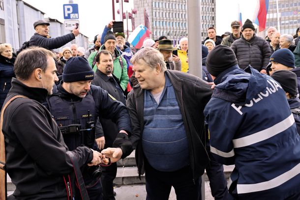 Udeleženec shoda, ki je napadel fotografa Mladine Gašperja Lešnika in zahteval, naj izbriše fotografije. Po prerivanju so pristopili policisti in protestnika odpeljali.